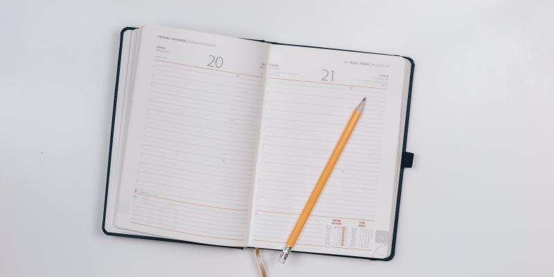 Open pocket calender with a pencil.