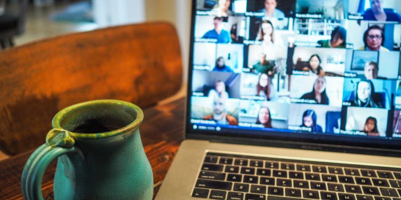 Laptop screen with faces on a Zoom call.