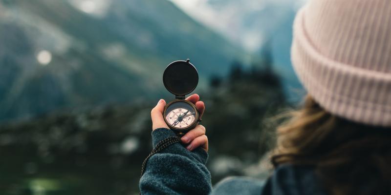 A person holding a compass in their hands. 