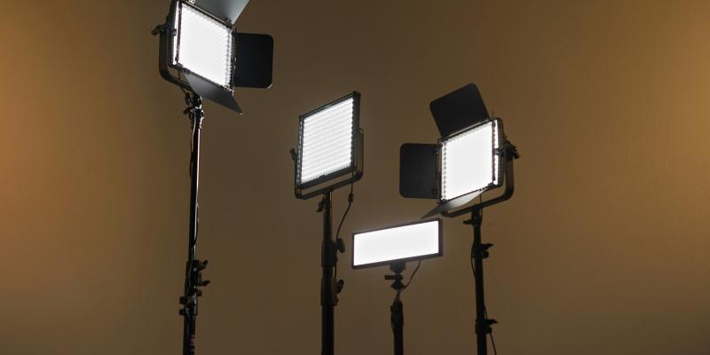 Neljä kuvauspaikan valaisinta tyhjää taustaa vasten.