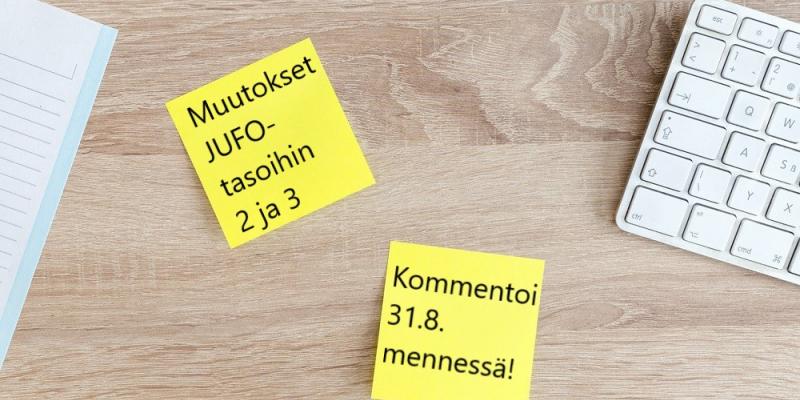 Kuvituskuva, jossa kaksi post it -lappua työpöydällä. Lapuissa lukee: "Muutokset JUFO-tasoihin 2 ja 3. Kommentoi 31.8. mennessä!". 