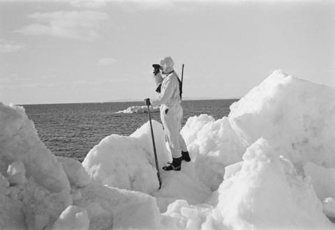 Hylkeenpyytäjä tähystää kiintojään reunalla, avoimen selän takana häämöttää Suursaari.