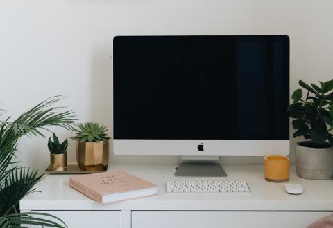 Image of an office desk with a screen and key on it 